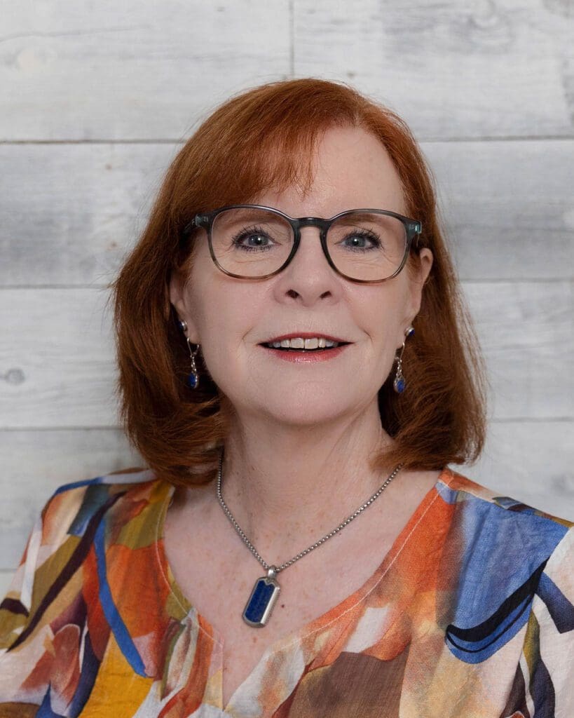 Red-haired woman with glasses smiling