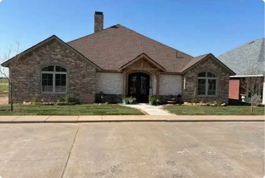 Single-story brick house with arched windows and a driveway.
