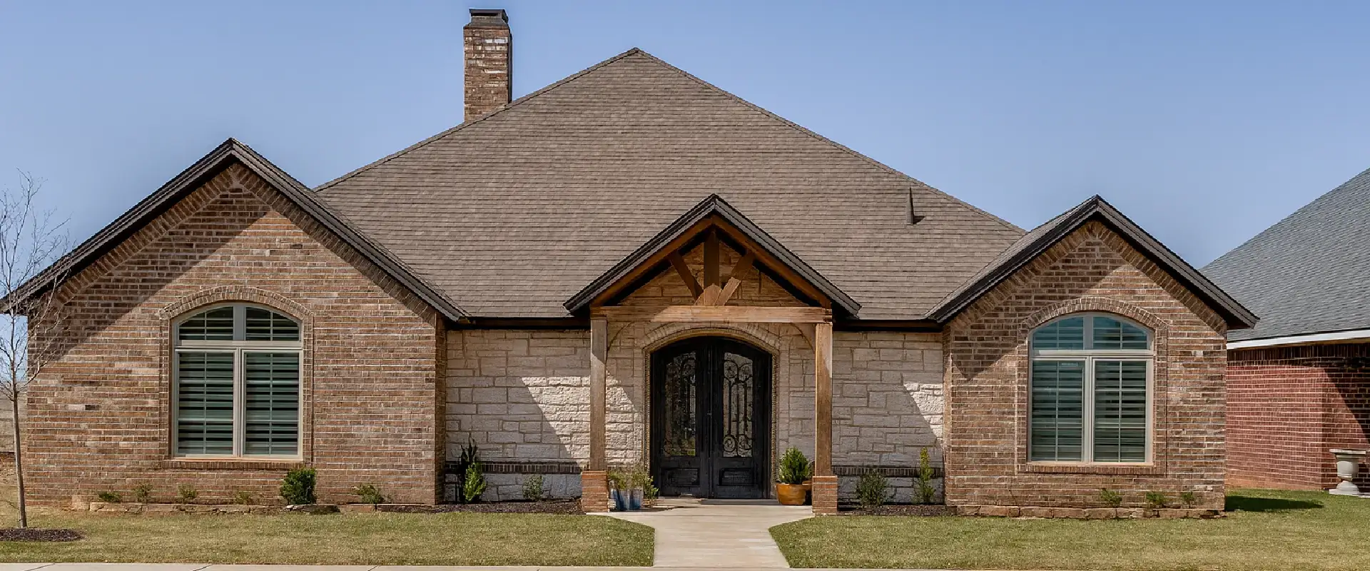 Single-story brick home with wooden porch beams